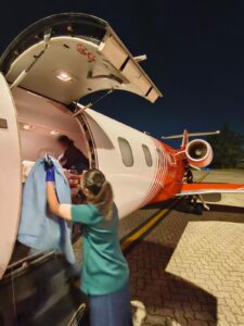 Medical crew loading equipment into an air ambulance for repatriation