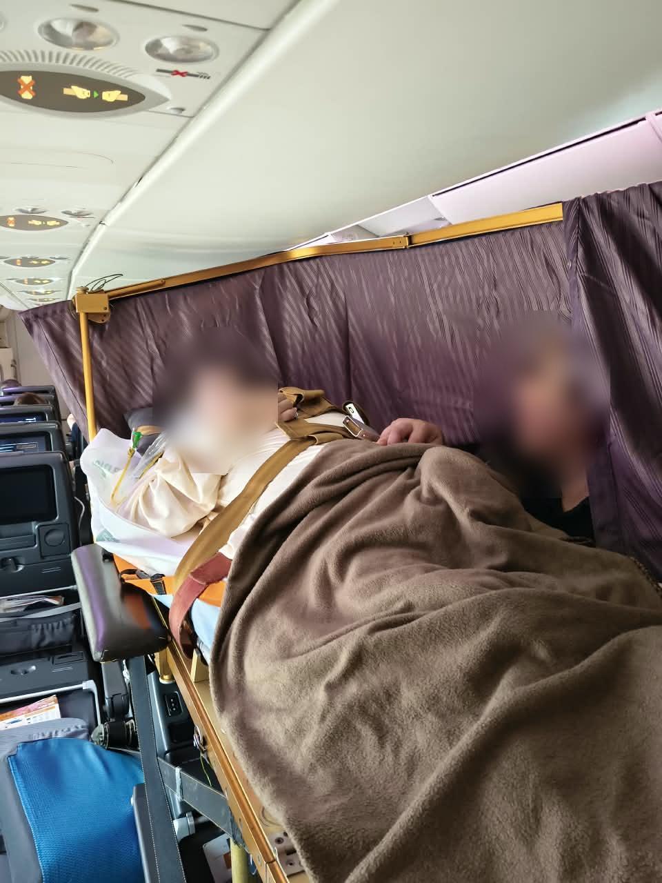 Commercial stretcher cabin setup during Shanghai to Singapore transfer (faces blurred for privacy)