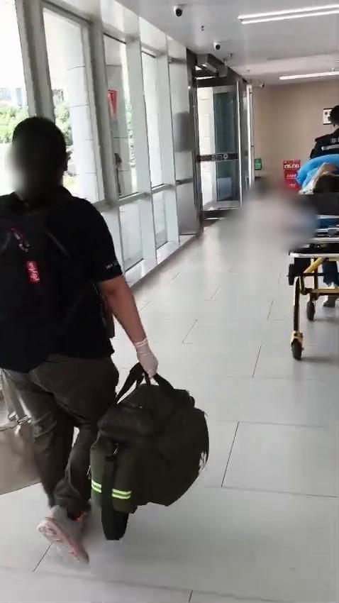 Medical team moving a stretcher along an airport corridor during repatriation (faces blurred)