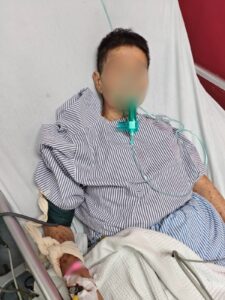Patient receiving oxygen and monitoring during medical repatriation (face blurred for privacy)